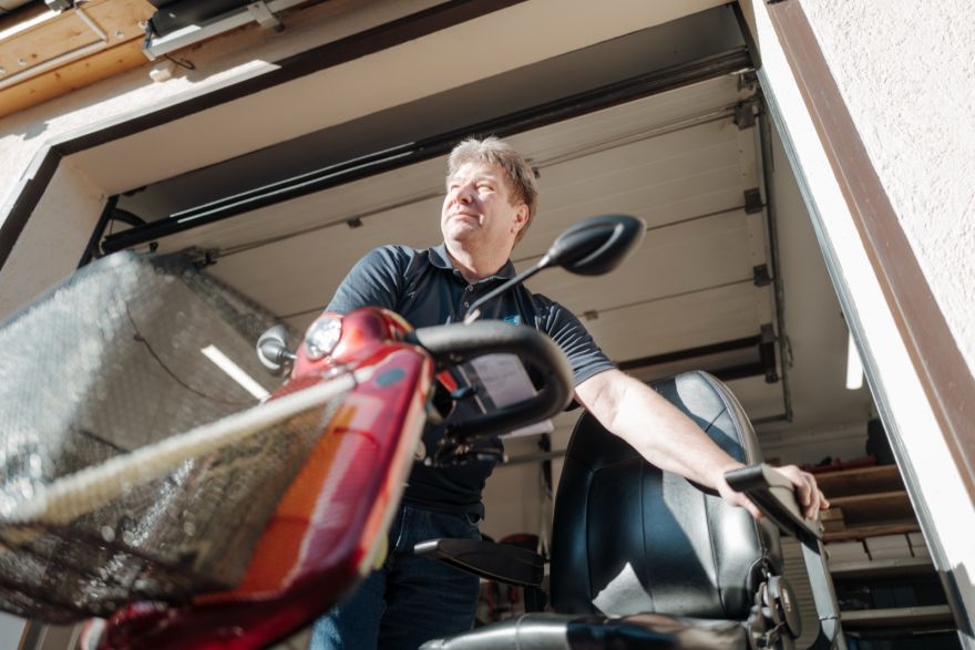 Mann fährt ein Elektromobil aus dem Ladengeschäft