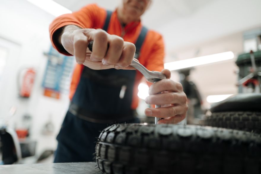 Mechaniker bei der Reparatur eines Seniorenmobil-Reifens